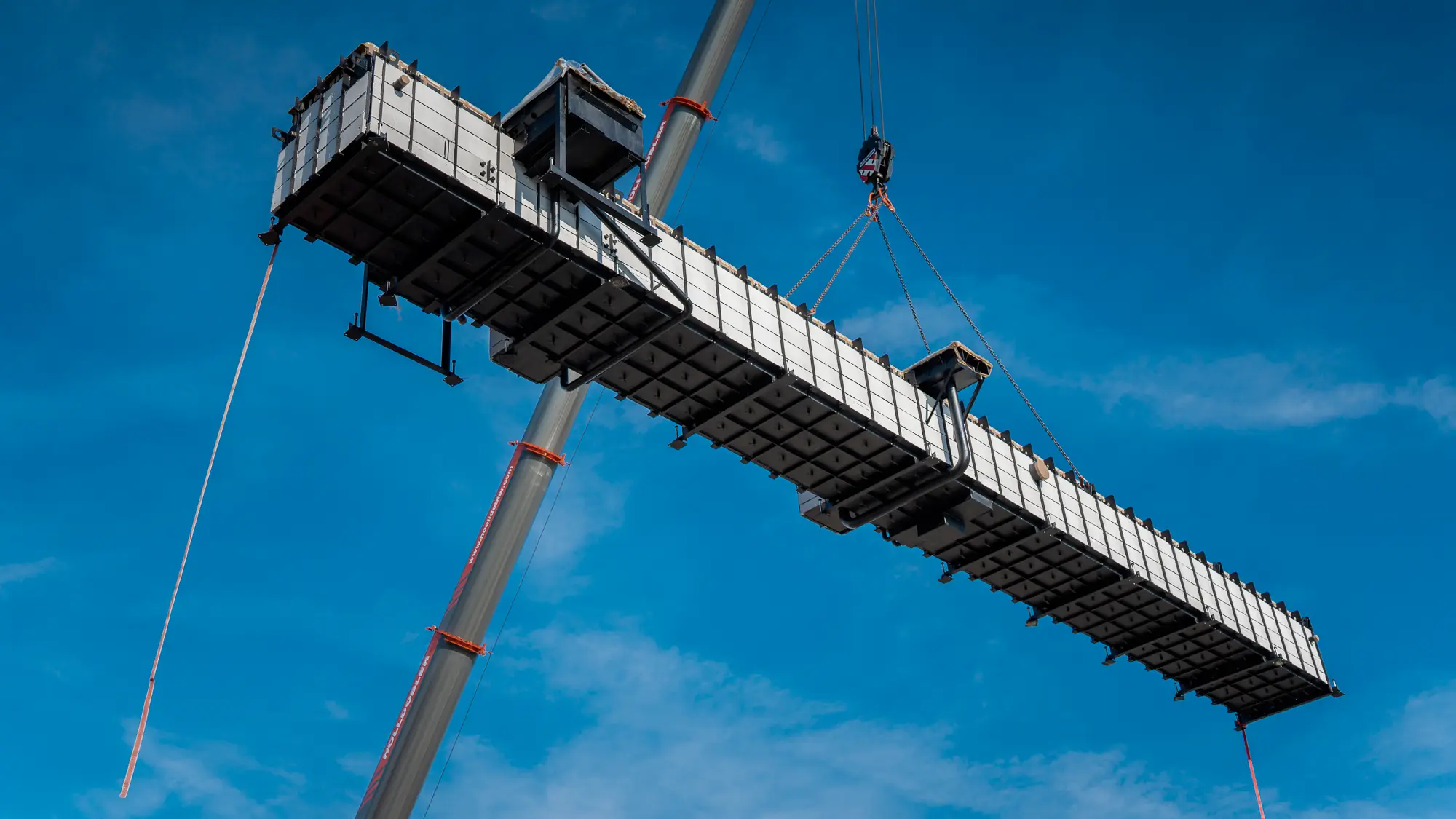 Eine truckcon Werkstattgrube bei der Montage am Kran hängend.